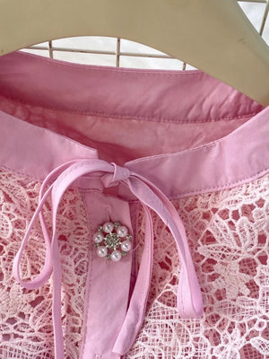 Blush pink lace two-piece ensemble with peplum, featuring a pearl and rhinestone brooch detail.