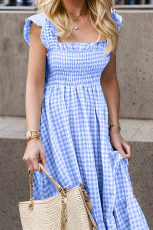 Blue gingham smocked maxi dress with flutter sleeves and square neckline.