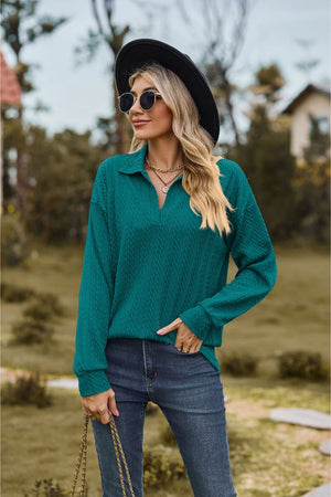 Turquoise textured cable knit polo top with a V-neck and long sleeves.