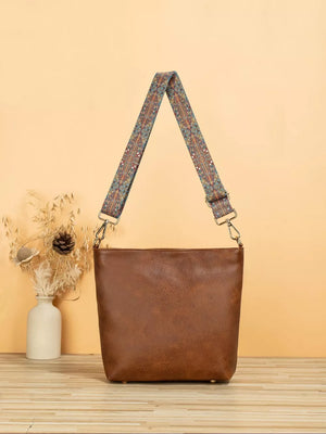 Tan pu leather crossbody bag with a colorful geometric strap.