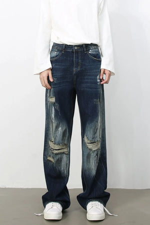Dark wash oversized wide leg jeans with distressed details and rips.