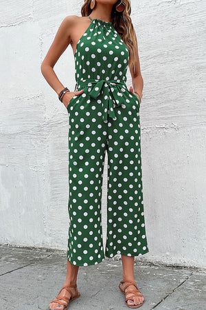 Green polka dot halter neck palazzo jumpsuit with tie belt and pockets.