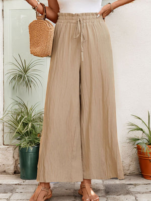 Tan textured wide-leg drawstring trousers with a ruffled waist.