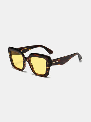 Geometric acetate sunglasses with yellow lenses and tortoise shell frames.