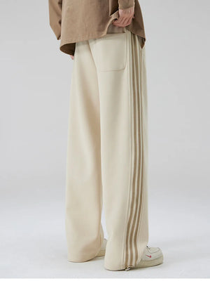 Khaki cotton sweatpants with wide legs and striped side detail.