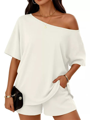 White asymmetrical one-shoulder top with pockets and matching shorts.