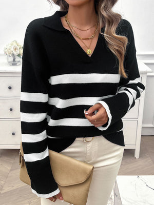 Black and white striped knit polo sweater with a v-neck and long sleeves.