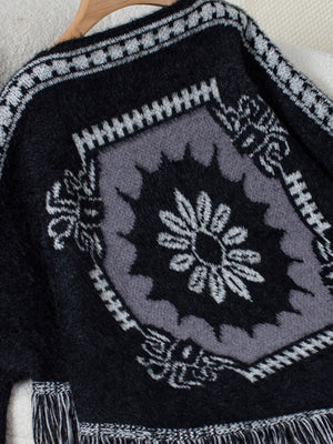 Black acrylic poncho with Aztec motif and fringe detail