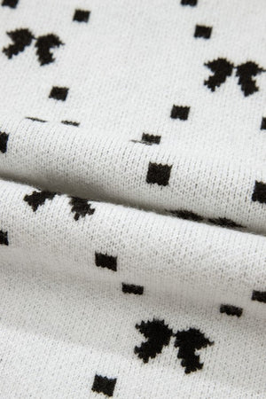White knit sweater with a black diamond bow pattern