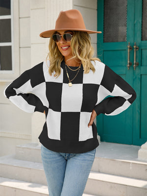 Checkerboard knit pullover sweater in black and white with balloon sleeves.