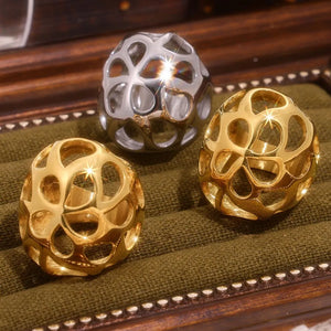 Openwork orb rings in gold and silver, featuring a hollow, geometric design.