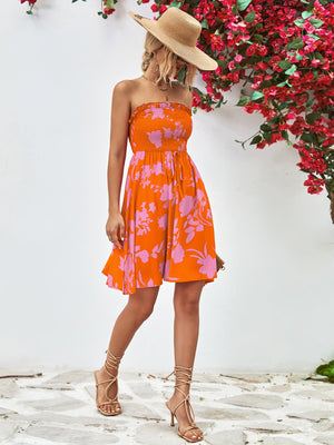 Orange floral smocked bandeau mini dress with drawstring waist and A-line skirt.