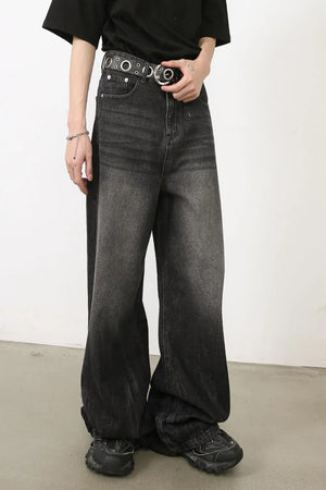Dark balloon-leg denim jeans with subtle fade and a black grommet belt.