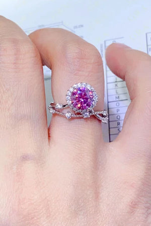 Pink moissanite halo ring with sterling silver band and accent stones.
