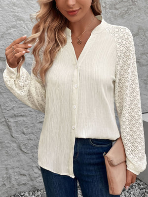 Cream lace sleeve raglan blouse with button front and textured fabric.