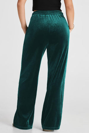 Dark green velvet palazzo lounge trousers with a relaxed fit and elastic waistband.