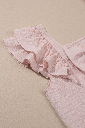 Blush pink textured blouse with ruffle cap sleeves and a V-neckline.
