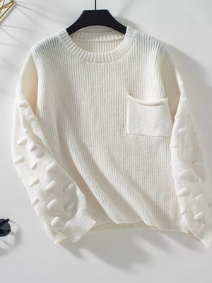 Ivory knit sweater with textured sleeves and chest pocket.