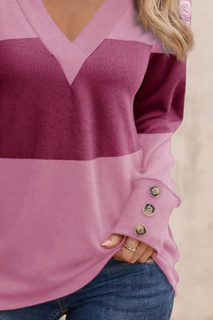 Pink and red-violet geometric V-neck knit top with button cuffs