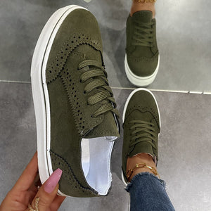 Green matte finish lace-up sneakers with brogue detailing and white soles.