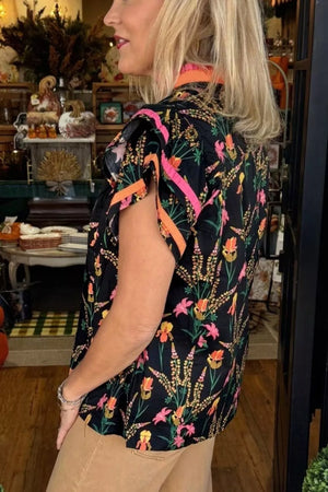 Black floral blouse with contrast trim, short sleeves, and a collared neckline.