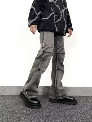 Men's relaxed fit washed flare jeans in grey denim with distressed details and paneling.