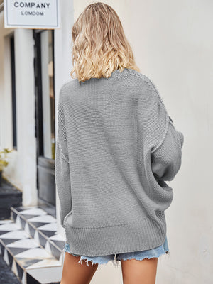 Oversized grey knit V-neck sweater with a slouchy fit and ribbed hem.