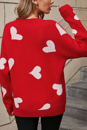 Red acrylic knit jumper with white intarsia hearts, crew neck, long sleeves.