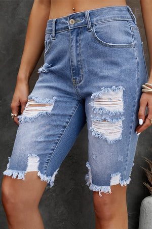 Light wash denim Bermuda shorts with ripped knees and frayed hem.