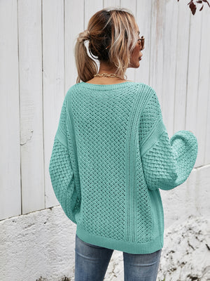 Teal open-knit sweater with balloon sleeves and a diamond pattern.