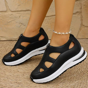 Black cutout wedge sneakers with zipper detail and chunky white sole.