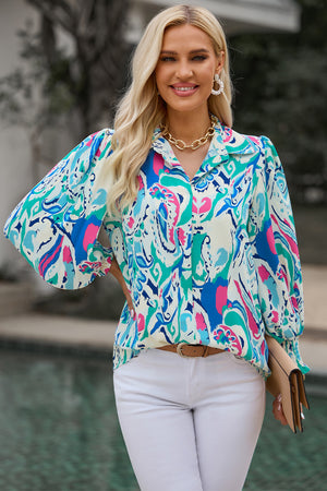 Women's abstract print blouse with gathered cuffs in blue and pink.