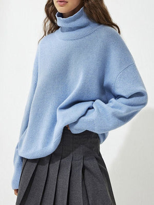 Light blue acrylic turtleneck sweater with sculptural sleeves and ribbed cuffs.