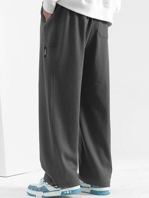 Men's dark gray casual loose-fit drawstring sweatpants with textured fabric and pockets.