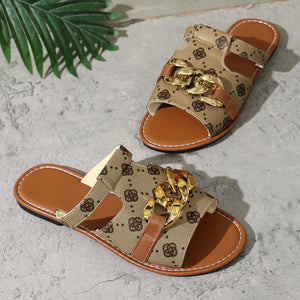 Patterned slide sandals in apricot with chain accent and brown trim.