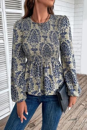 Navy damask print smocked peplum blouse with long sleeves and a crew neck.