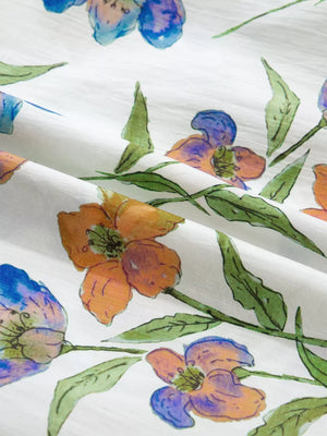 Cotton shirt with vibrant floral print, blue and orange flowers, green leaves, V-neck detail.