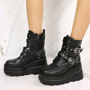 Black platform combat boots with buckles, studs, and laces.