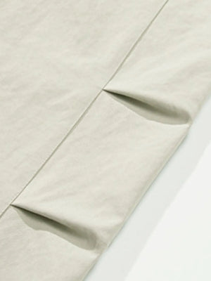 Balloon-fit trousers in light gray with subtle pleating detail.