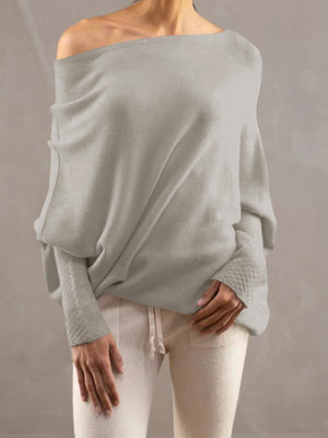 Light Gray off-shoulder knit sweater with textured cuffs and draped neckline.