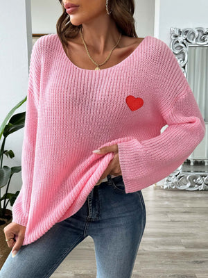 Pink slouchy boatneck knit sweater with embroidered red heart detail.