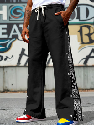 Black wide leg sweatpants with drawstring and side snaps featuring bandana print detail.