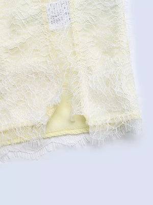Lace-trimmed midi slip dress in pale yellow with a side slit and delicate lace hem.