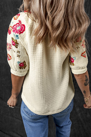 Beige embroidered sleeve blouse with voluminous puff sleeves and textured fabric.