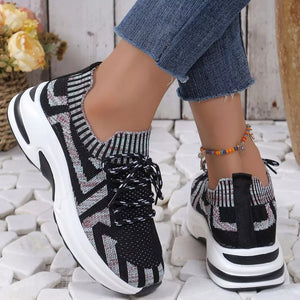 Geometric knit platform sneakers in black with white and red zigzag pattern and white laces.