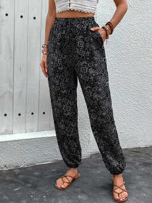 Black printed jogger trousers with gathered ankles and pockets.