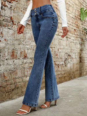 Medium wash denim bootcut jeans with a high rise and button fly, styled with white heels.