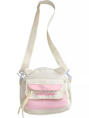 White and pink crossbody bag with cat ears and adjustable strap.