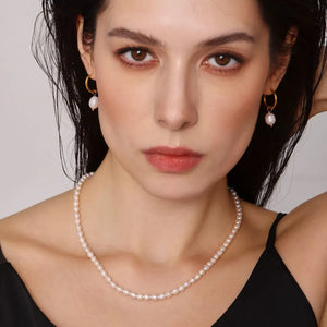 Gold pearl necklace and hoop earrings set with pearl drops.