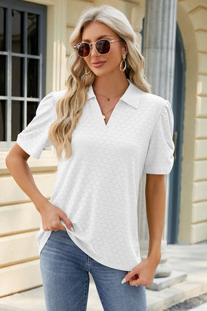 White perforated polo top with short puff sleeves and a v-neck.